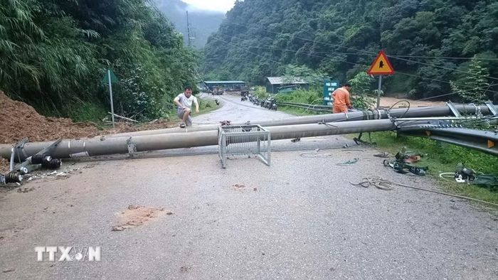 Mưa lớn kéo dài gây sạt lở và làm đổ cột điện xuống đường tại xã Khao Mang. (Ảnh: TTXVN phát)