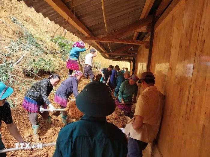 Các lực lượng xã Púng Luông hỗ trợ người dân khắc phục hậu quả thiên tai. (Ảnh: TTXVN phát)