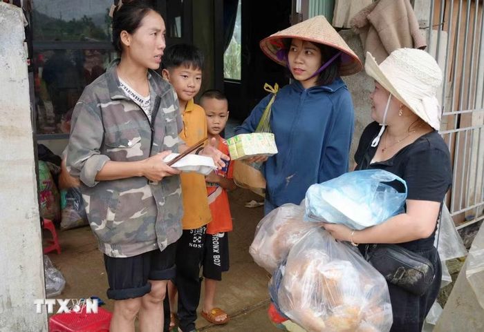 Tiếp tế thực phẩm cho những gia đình bị lũ cuốn trôi. (Ảnh: Nguyễn Oanh/TTXVN)