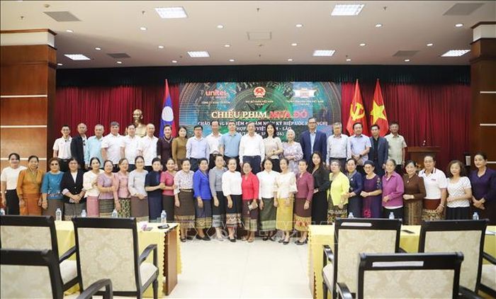 Đại sứ Nguyễn Minh Tâm và các đại biểu tham gia xem phim "Mưa Đỏ" chụp ảnh kỷ niệm. Ảnh: Xuân Tú/PV TTXVN tại Lào