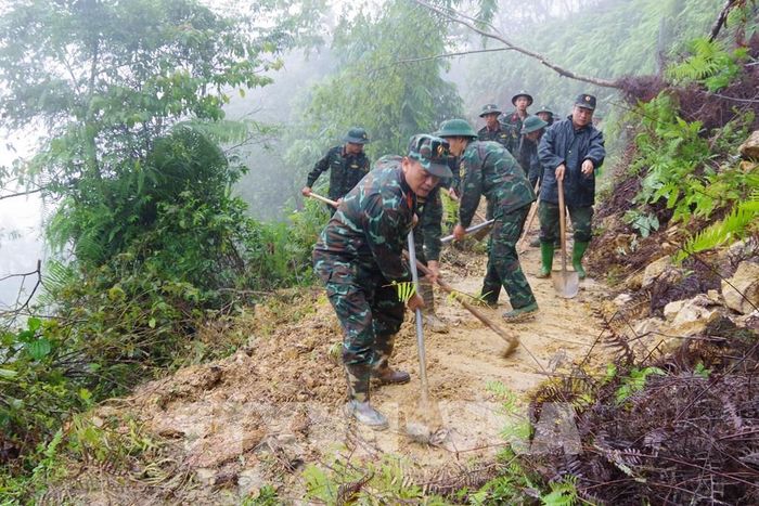 Cán bộ, chiến sĩ dọn dẹp đất đá, cây cối đổ gãy, khôi phục các tuyến giao thông tại xã Mù Cang Chải. Ảnh: TTXVN phát