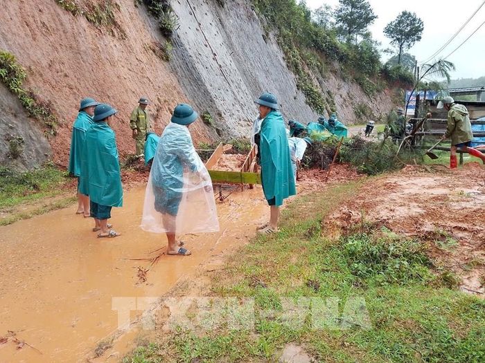 Các lực lượng khắc phục điểm sạt lở đường giao thông ở xã Púng Luông. Ảnh: TTXVN phát