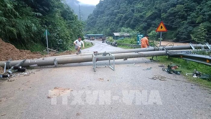 Mưa lớn kéo dài gây sạt lở và làm đổ cột điện xuống đường tại xã Khao Mang. Ảnh: TTXVN phát
