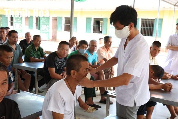 Các đối tượng được hướng dẫn đeo khẩu trang, ngồi chờ theo từng nhóm trước khi thăm khám.