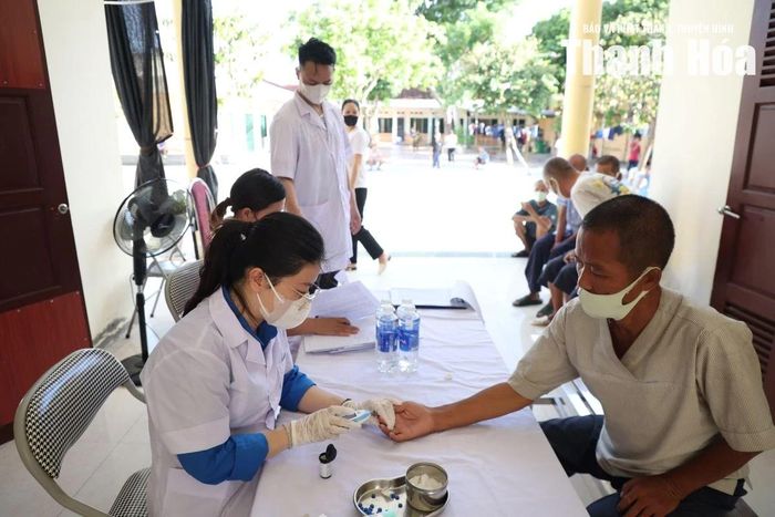 Nhân viên y tế thực hiện xét nghiệm đường huyết mao mạch cho người bệnh.