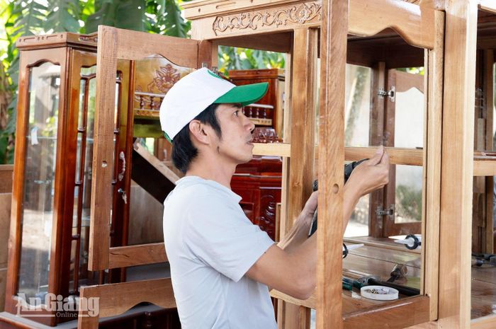 Thợ lắp kính tủ trước khi giao cho khách hàng.