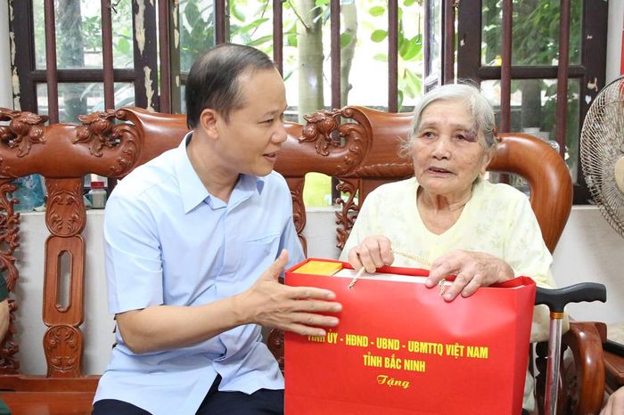 Đồng chí Mai Sơn tặng quà bà Nguyễn Thị Ngoan, vợ liệt sĩ.