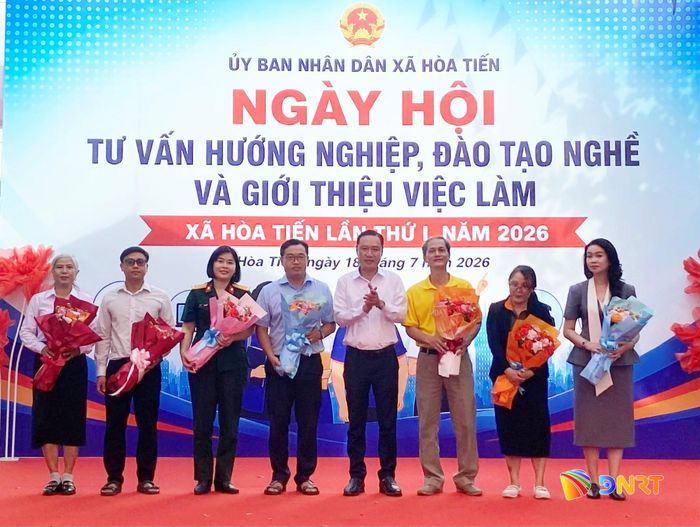 Lãnh đạo xã Hòa Tiến tặng hoa cho đại diện các cơ sở đào tạo, doanh nghiệp tham gia ngày hội. Ảnh: KHÁNH LINH