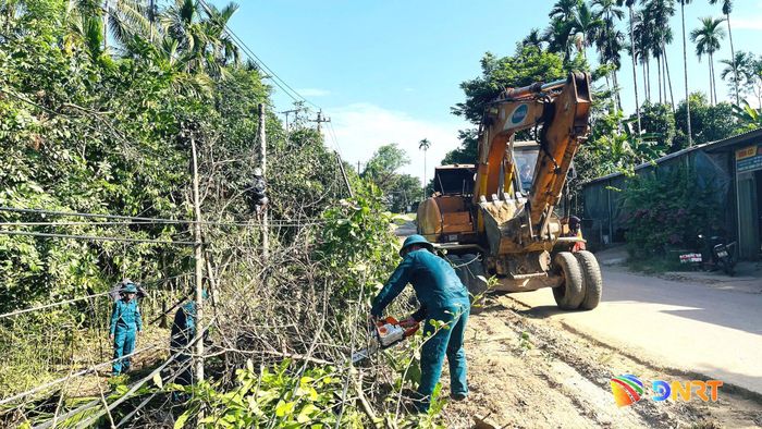 Lực lượng dân quân dọn cây cối ven quốc lộ 40B để có mặt bằng thi công dự án. Ảnh: CÔNG TÚ