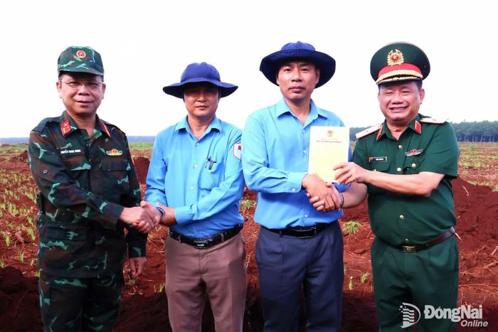 Thiếu tướng Trần Chí Tâm và Đại tá Nguyễn Thanh Phong tặng quà cho Đội K72 đang thực hiện nhiệm vụ tại xã Minh Đức. Ảnh: Nguyệt Hà