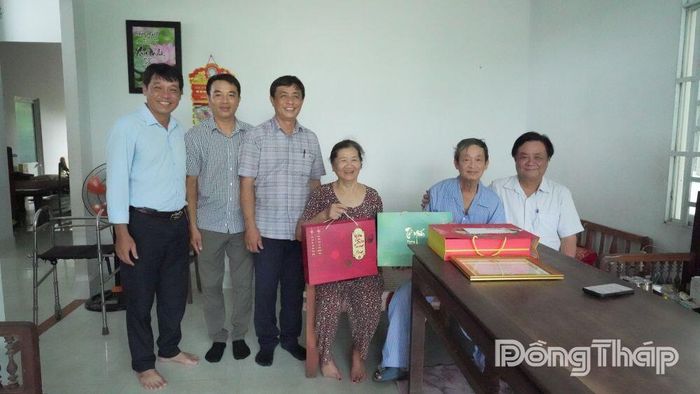 Đồng chí Lê Minh Hoan chụp ảnh lưu niệm cùng gia đình ông Lê Thành Lộc.