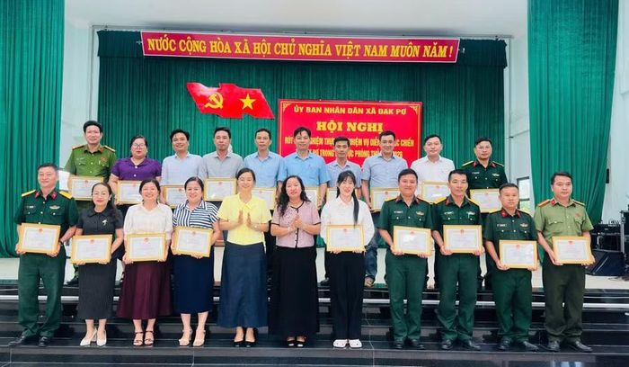  Chủ tịch UBND xã Đak Pơ tặng giấy khen các tập thể, cá nhân có thành tích xuất sắc trong thực hiện nhiệm vụ diễn tập. Ảnh: N.T 