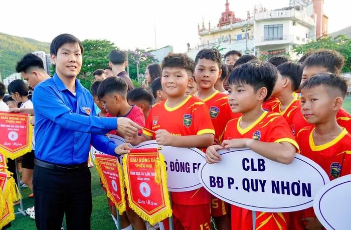 Anh Trần Ngọc Quỳnh - Phó Giám đốc Thường trực Trung tâm Hoạt động Thanh thiếu nhi tỉnh Gia Lai tặng cờ lưu niệm cho các vận động viên tham gia giải đấu. Ảnh: D.L