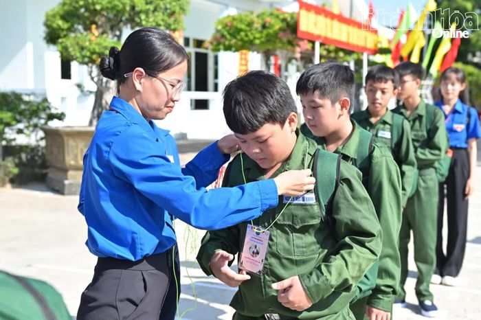 Ban tổ chức đeo thẻ học viên cho các chiến sĩ nhí.