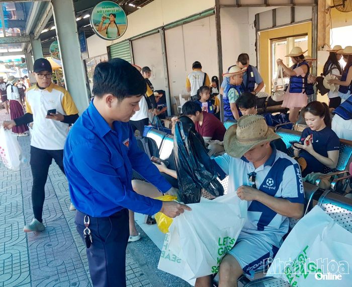  Đoàn viên, thanh niên Ban Quản lý vịnh Nha Trang phát miễn phí túi phân hủy sinh học thân thiện với môi trường cho du khách.