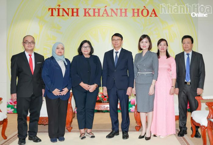 Đồng chí Nguyễn Thanh Hà và bà Carolina Tinangon cùng các thành viên đoàn công tác chụp hình lưu niệm.