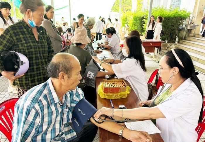 Các y, bác sĩ đo huyết áp cho người dân.