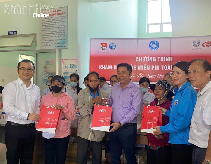 Đại diện các đơn vị tặng quà cho người dân đến khám bệnh.