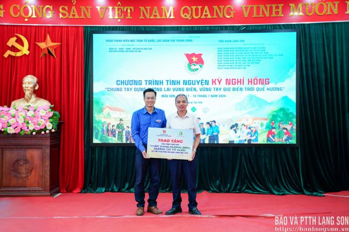 Đại diện Ban Tổ chức trao tặng biển tượng trưng công trình thanh niên “Thắp sáng đường biên” cho đại diện lãnh đạo xã Mẫu Sơn