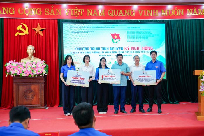 Đại diện Ban Tổ chức trao tặng biển tượng trưng khu sân chơi cho thiếu nhi khu vực biên giới; mô hình khởi nghiệp với 5.000 cây keo, mô hình sinh kế gồm 1.000 gói hạt giống cho đại diện lãnh đạo xã Mẫu Sơn