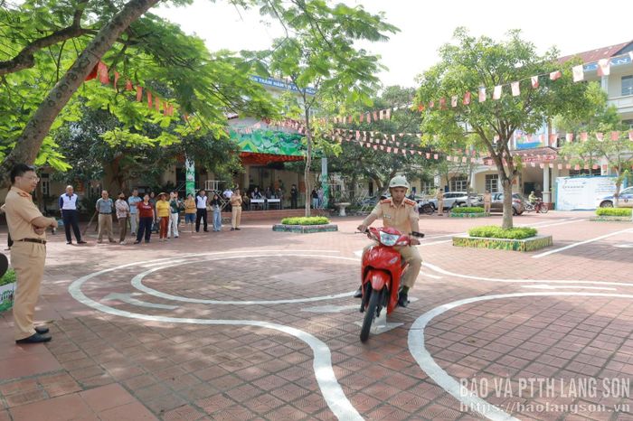 Cán bộ Phòng CSGT, Công an tỉnh, hướng dẫn người dân thực hành đi trong sa hình để thi giấy phép lái xe mô tô