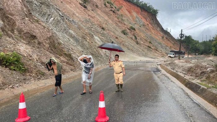 Công an tỉnh Lào Cai kịp thời đưa 2 tài xế rời khỏi khu vực có nguy cơ sạt lở.