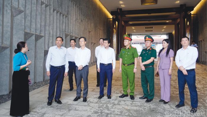 Hướng dẫn viên giới thiệu cho đoàn công tác về Đền thờ liệt sĩ tại Chiến trường Điện Biên Phủ.