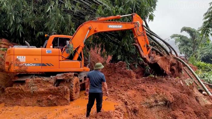 Máy xúc được huy động để giải tỏa đất đá trên các tuyến đường giao thông.
