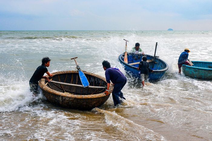 Các ngư dân vùng biển xã Tân Hải thi khiêng thúng ra khơi