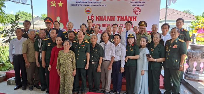 Các đại biểu và đại diện gia đình ông Trần Bích chụp ảnh lưu niệm tại lễ khánh thành Nhà bia tưởng niệm 13 liệt sĩ - Ảnh: N.V