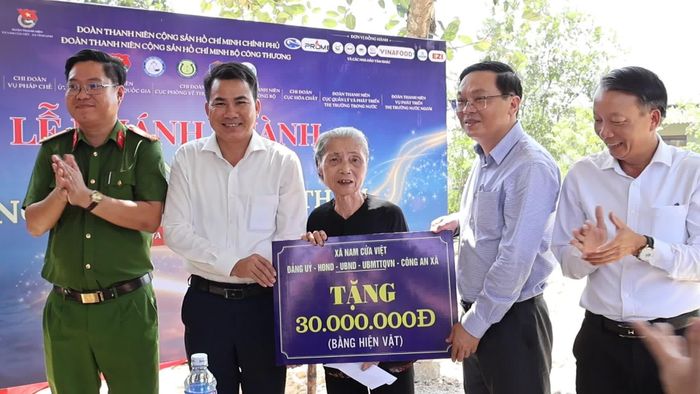 Đại diện lãnh đạo xã Nam Cửa Việt trao quà cho bà Nguyễn Thị Thâm, ở thôn Lưỡng Kim, xã Nam Cửa Việt - Ảnh: H.T
