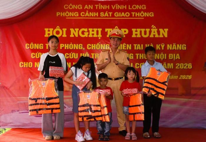 Thượng tá Trần Ngọc Đời, Phó trưởng Phòng CSGT tặng áo phao, tập vở cho các em học sinh.