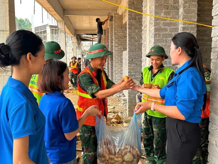 Lực lượng đoàn viên thanh niên "tiếp sức" bánh cho lực lượng đang trực tiếp thi công tại công trình Trường phổ thông nội trú Tiểu học và THCS Phục Hòa.