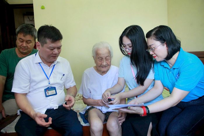 Cán bộ UBND phường Văn Miếu - Quốc Tử Giám, Trung tâm Phục vụ hành chính công thành phố Hà Nội Chi nhánh số 3 và Bảo hiểm xã hội cơ sở Hoàn Kiếm đến tận nhà cụ Mùi để hướng dẫn, xác minh và hoàn thiện toàn bộ thủ tục. Ảnh: Hồng Nhung
