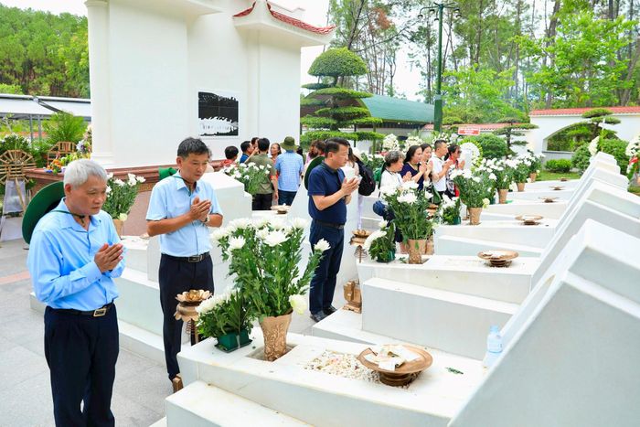 Các thành viên đoàn công tác của Hà Nội thắp hương tại khu mộ các liệt sĩ ở Ngã ba Đồng Lộc. Ảnh: Mai Hoa