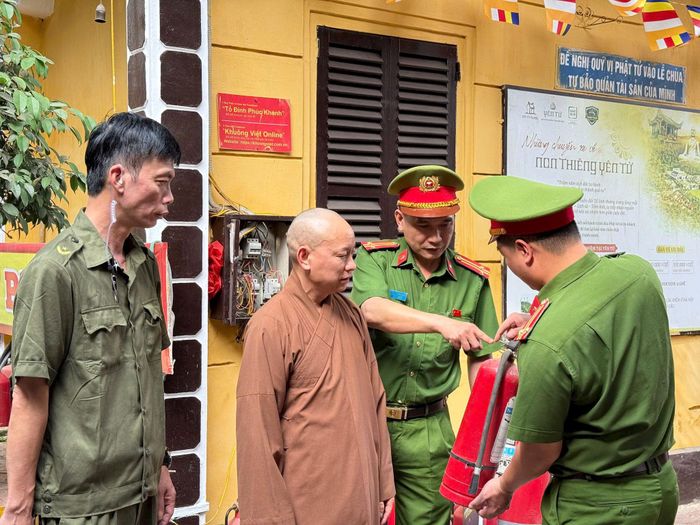 Công an phường Đống Đa tuyên truyền bảo đảm quy định phòng cháy, chữa cháy tại các điểm đến tâm linh. Ảnh: PV