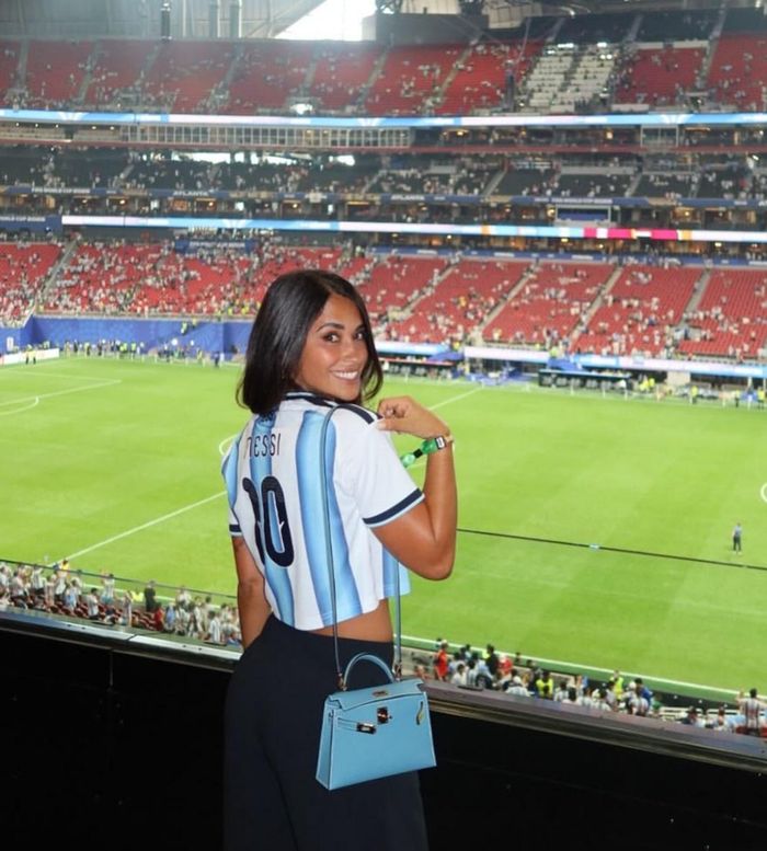 Trước đó, trong trận Argentina - Ai Cập diễn ra vào đêm 7/7 (giờ Việt Nam), nàng WAG xách chiếc túi Hermès Bleu Celeste Kelly. Trong khi màu xanh dương gợi liên tưởng đến sắc áo của đội tuyển quốc gia Argentina, dòng Kelly nhỏ gọn, năng động cũng phù hợp với trang phục thể thao. Chiếc túi sở hữu lớp lót da bê cùng tông màu. Nắp khóa mạ palladium trở thành điểm nhấn của món đồ thời trang. Vợ Messi sử dụng dây đeo dài, khoác chiếc Hermès trên vai, thể hiện sự tinh tế trong khâu lựa chọn trang phục, phối đồ. Món đồ được bán với giá thành 14.000-17.000 USD (khoảng 368 triệu đồng đến 446 triệu đồng) trên website của nhà đấu giá hàng đầu Sotheby’s. Ảnh: @antonelaroccuzzo.