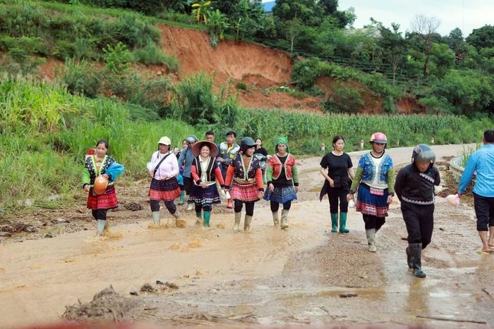 Sau khi trời ngớt mưa, cơn lũ đã đi qua, người dân vui mừng trở về nhà. Ảnh: Quý Trung - TTXVN