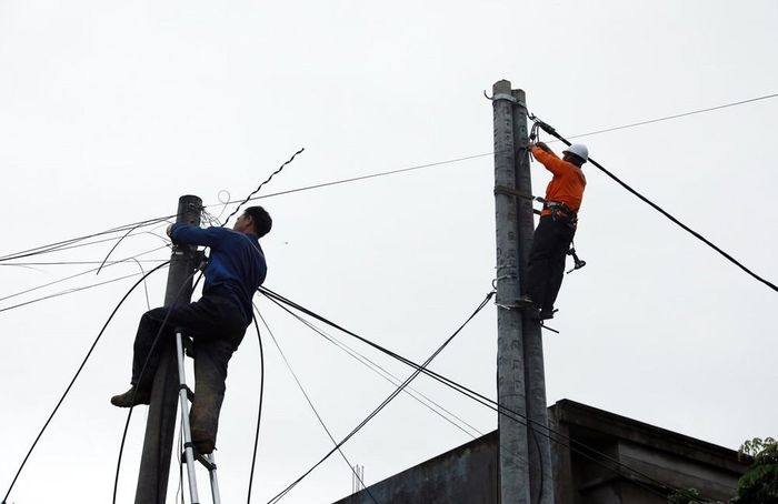Nhà mạng viễn thông cùng công nhân Công ty điện lực Lai Châu tập trung khắc phục hạ tầng, góp phần sớm ổn định cuộc sống người dân sau lũ dữ. Ảnh: Quý Trung - TTXVN