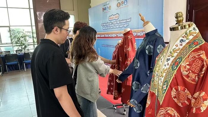 Các bạn trẻ tìm hiểu các mẫu Việt phục được trưng bày tại Trường đại học Khoa học Xã hội và Nhân văn Thành phố Hồ Chí Minh.