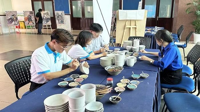 Các bạn trẻ trải nghiệm cách vẽ trang trí gốm Lái Thiêu tại Trường đại học Khoa học Xã hội và Nhân văn Thành phố Hồ Chí Minh.