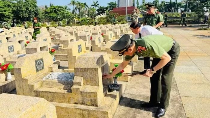 Đại tướng Lương Tam Quang thắp hương mộ phần các liệt sĩ. (Ảnh: Nguyễn Hân)