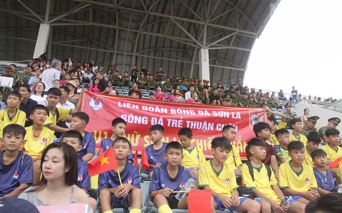 Các cầu thủ bóng đá trẻ Thuận Châu cùng với băng rôn cũng tham gia cổ vũ cho đội chủ nhà Sơn La.