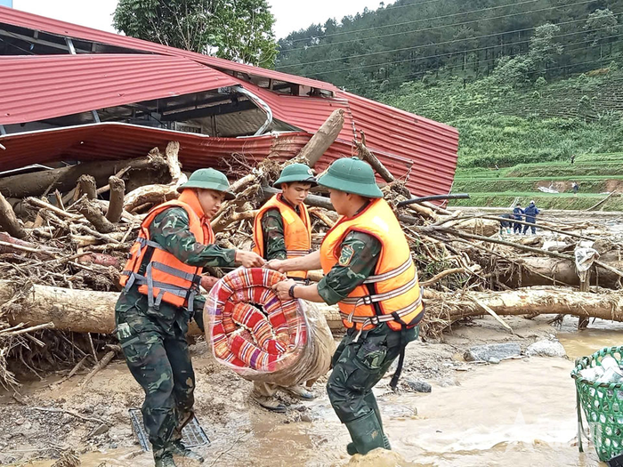 Cán bộ, chiến sĩ Trung đoàn 880, Bộ CHQS tỉnh Lai Châu hỗ trợ nhân dân xã Mường Than, tỉnh Lai Châu di dời tài sản đến nơi an toàn.