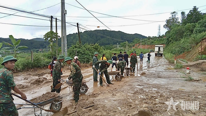 Cán bộ, chiến sĩ Trung đoàn 880, Bộ CHQS tỉnh Lai Châu phối hợp với các lực lượng san gạt bùn đất trên Quốc lộ 32 đoạn qua địa bàn xã Mường Than.