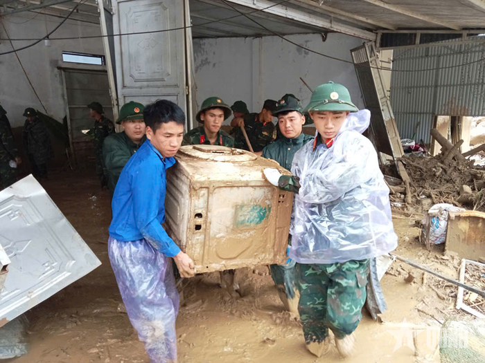 Cán bộ, chiến sĩ Trung đoàn 880, Bộ CHQS tỉnh Lai Châu hỗ trợ nhân dân xã Mường Than di dời tài sản đến nơi an toàn.
