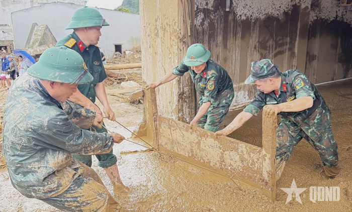 Cán bộ, chiến sĩ Trung đoàn 880, Bộ CHQS tỉnh Lai Châu hỗ trợ nhân dân xã Mường Than san gạt bùn đất.