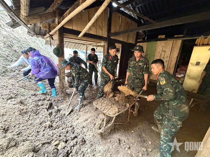 Cán bộ, chiến sĩ Trung đoàn 121, Bộ CHQS tỉnh Lào Cai san gạt, thu dọn bùn, đất đá trên đường giao thông tại địa bàn xã Mù Cang Chải.