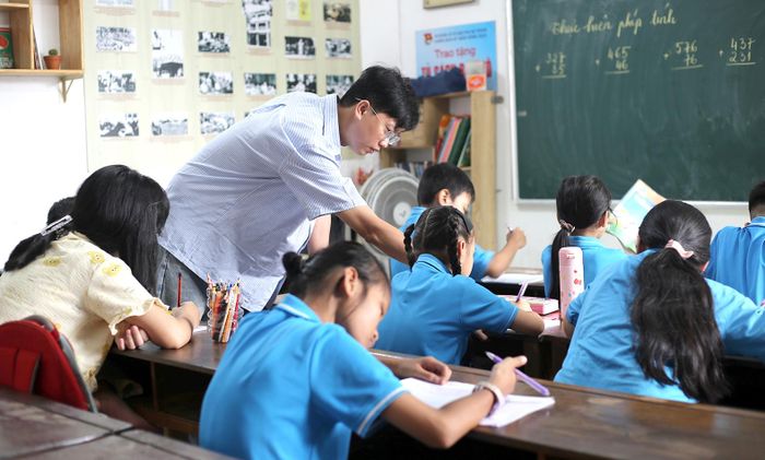Thầy Huỳnh Ngọc Sang tranh thủ những ngày hè đến dạy tại lớp học tình thương của cô Út. Ảnh: DIỄM MI