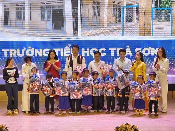 Đại diện Trường Liên cấp Thành phố Giáo dục Quốc tế IEC Quảng Ngãi trao quà cho học sinh Trường Tiểu học Trà Sơn.